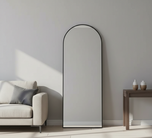 Arched floor mirror leaning against a wall