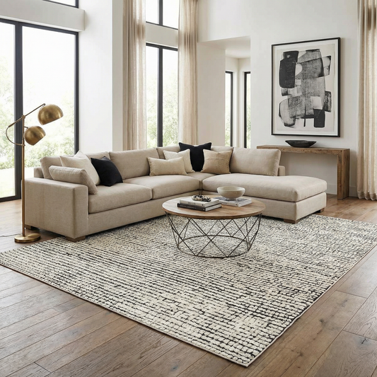 Modern living room with a beige sectional sofa, coffee table, and abstract art on the wall.