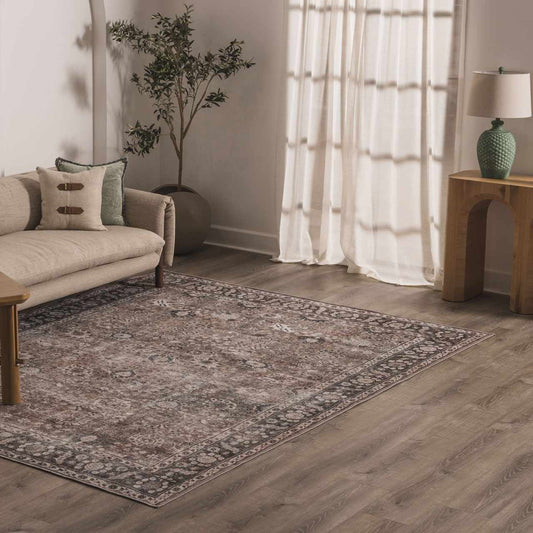 Living room with a patterned rug, sofa, and side table.