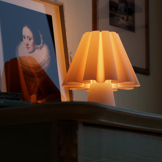 Ruff Lamp lit on a mantel beside a framed 17th-century portrait of a woman wearing a pleated ruff collar