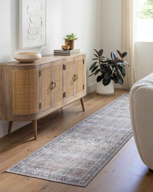 Wooden sideboard in a living room with a rug and plant